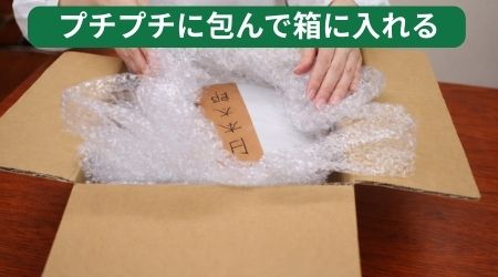 骨壷をプチプチに包んで箱に入れる